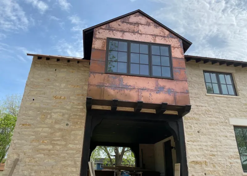 Copper metal panel facade on a stone building for Skylight Installation in Webster City