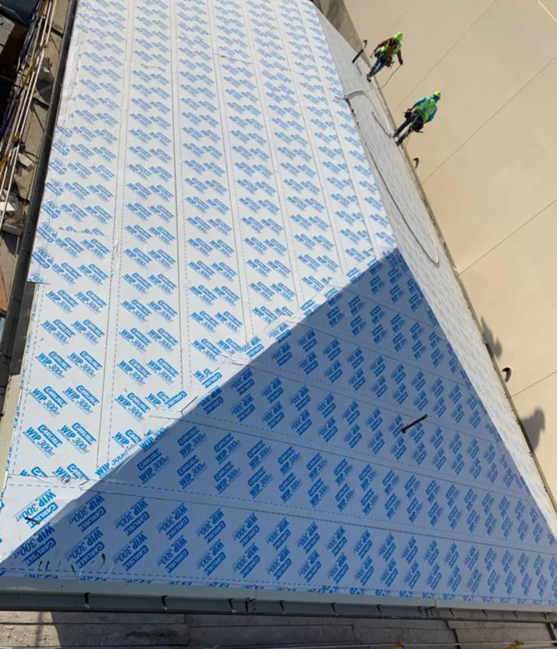 Professional roofers installing underlayment on a metal roof in Webster City